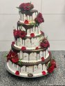 Tort weselny z rozami, oblany czekoladą