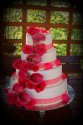 Piętrowy tort weselny z dodatkiem czerwonych kwiatów